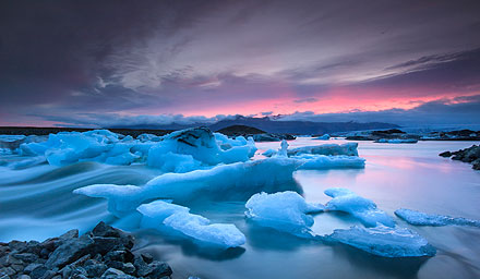 Iceland landscaping including ice caps and water against a pink sunset sky